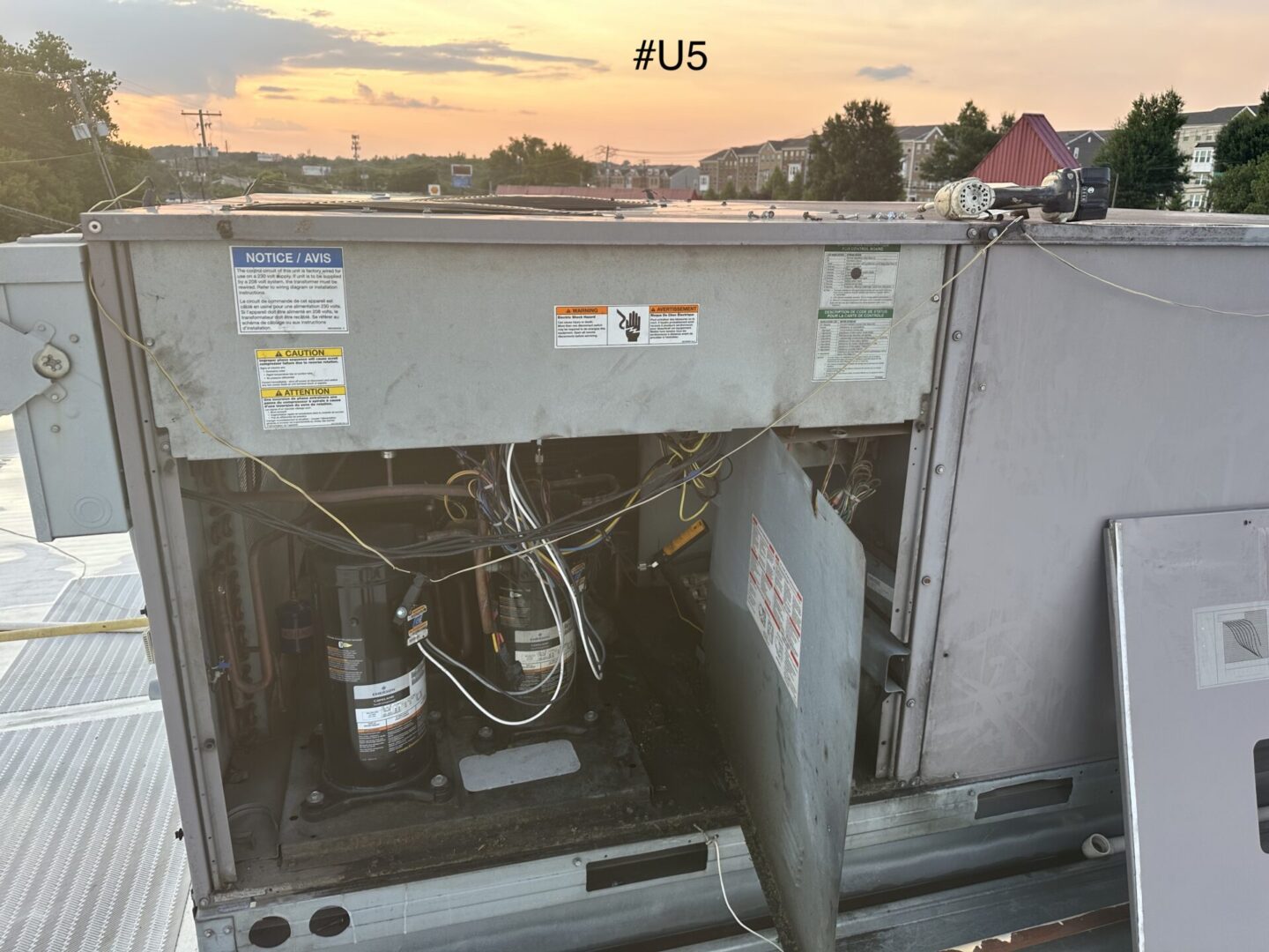 Open rooftop HVAC unit showing compressors and wires